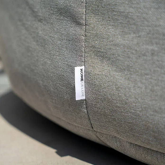 Home Deluxe Gartenhocker CLOUD Pouf - Hellgrau, B x T x H: 140 x 140 x 40 cm - Nahaufnahme eines grauen, strukturierten Stoff-Sitzsacks mit weißem "HOME DELUXE"-Etikett.