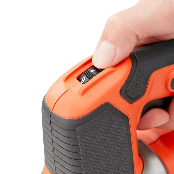 Black+Decker Elektro-Stichsäge BES610K-QS - 1.000 /min - 3.100 /min, 90 mm - Nahaufnahme eines orangefarbenen Geräts mit einem verstellbaren Drehknopf, der auf Stufe 7 steht, bedient von einem Finger.