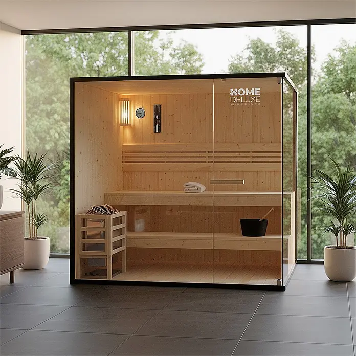 Home Deluxe Elementsauna SHADOW XL - Elektroofen, Steuerung Ofen: Integriert - Moderne Indoor-Saunakabine mit hellem Holzinterieur, klarer Glasfront und schwarzem Rahmen in einem hellen Raum.