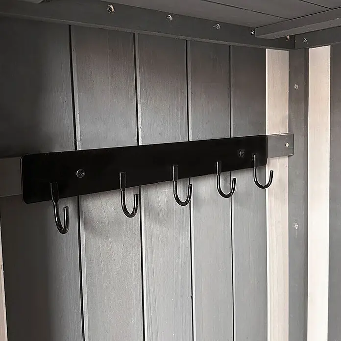 Home Deluxe Geräteschrank YANA XL - Außenbreite inkl. Dachüberstand: 77 cm, Außentiefe inkl. Dachüberstand: 54 cm, Holz, Grau - Schwarze Metallhakenleiste mit fünf Haken, montiert an einer grauen Lattenwand aus Holz.