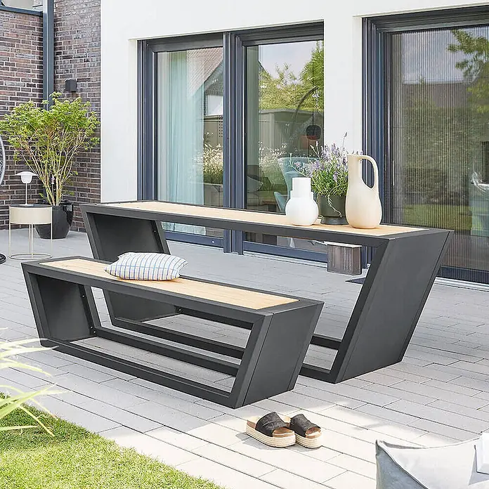 Home Deluxe Gartentisch-Set KOBON - Gesamtumfang: 2 -tlg. - Moderne Outdoor-Tisch-Bank-Gruppe mit dunkelgrauen Metallrahmen und hellen Holzplatten auf einer Terrasse.