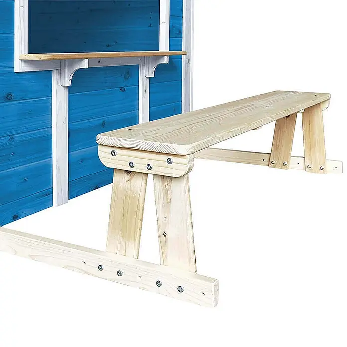 Home Deluxe Spielhaus DER GROSSE PALAST mit Bank - L x B x H: 111 x 118,2 x 132,5 cm, Holz, Blau - Helle Holz-Picknickbank für ein Spielhaus, neben einer blauen Wand mit Servierfenster.