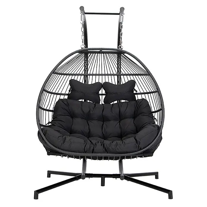 Home Deluxe Hängesessel LOMA 2-Sitzer - Kunststoff, Schwarz - Schwarzer Doppelschaukelstuhl in Eiform mit geflochtenem Rahmen und plüschigen schwarzen Kissen auf einem Ständer.