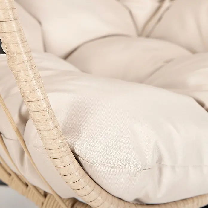 Home Deluxe Hängesessel LOMA 1-Sitzer - Kunststoff, Beige - Nahaufnahme eines hellbeigen, getufteten Kissens in einem geflochtenen Rattansessel.