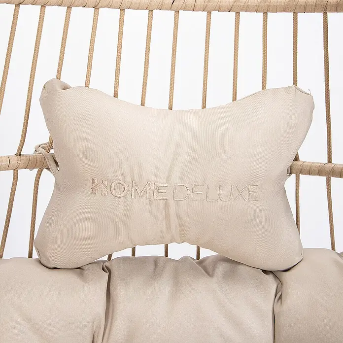 Home Deluxe Hängesessel LOMA 1-Sitzer - Kunststoff, Beige - Beiges Textil-Kopfkissen mit gesticktem 'HOME DELUXE'-Logo, an einem Rattanstuhl befestigt, mit passendem Unterkissen.