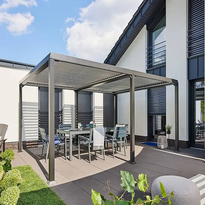 Home Deluxe Pergola CANNES - B x T: 400 x 303 cm, Farbe Gestell: Anthrazit, Aluminium - Dunkelgraue Lamellenpergola über Essgruppe auf einer Terrasse.