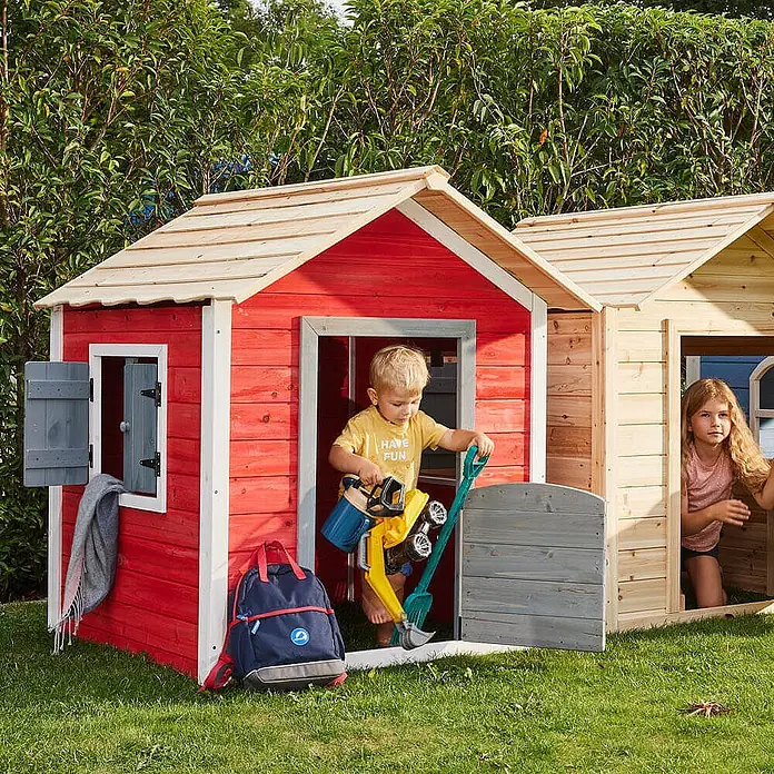 Home Deluxe Spielhaus DAS KLEINE SCHLOSS - Holz, Rot - Zwei Holzspielhäuser, rot und naturfarben, mit spielenden Kindern.