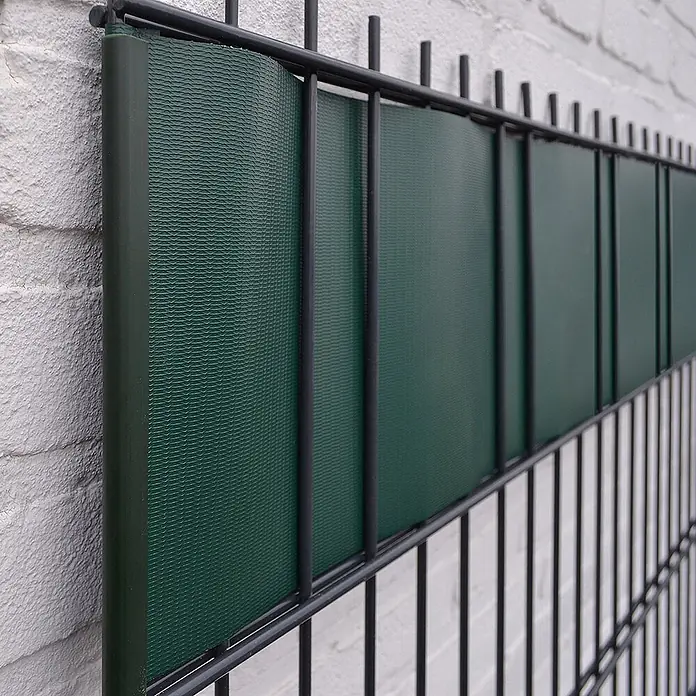 Home Deluxe Mattenzaun Sichtschutzfolie MATA - Kunststoff, Moosgrün - Dunkelgrüne, texturierte Sichtschutzstreifen in einem schwarzen Metallgitterzaun.