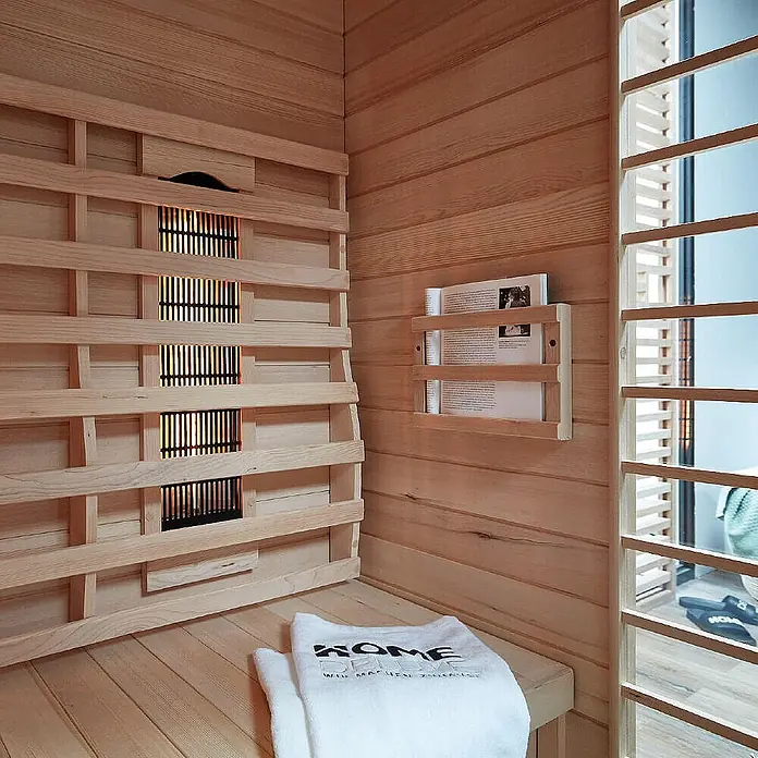 Home Deluxe Infrarotkabine REDSUN DELUXE XXL -  - Infrarotsauna-Innenraum aus hellem Holz mit glühenden Heizelementen und einer Holzbank.