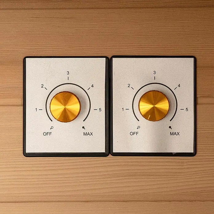 Home Deluxe Infrarotkabine REDSUN DELUXE XL -  - Zwei Bedienfelder mit goldenen Knöpfen auf einer Holzoberfläche, jeweils mit Einstellungen von AUS bis MAX und Zahlen 1-5.