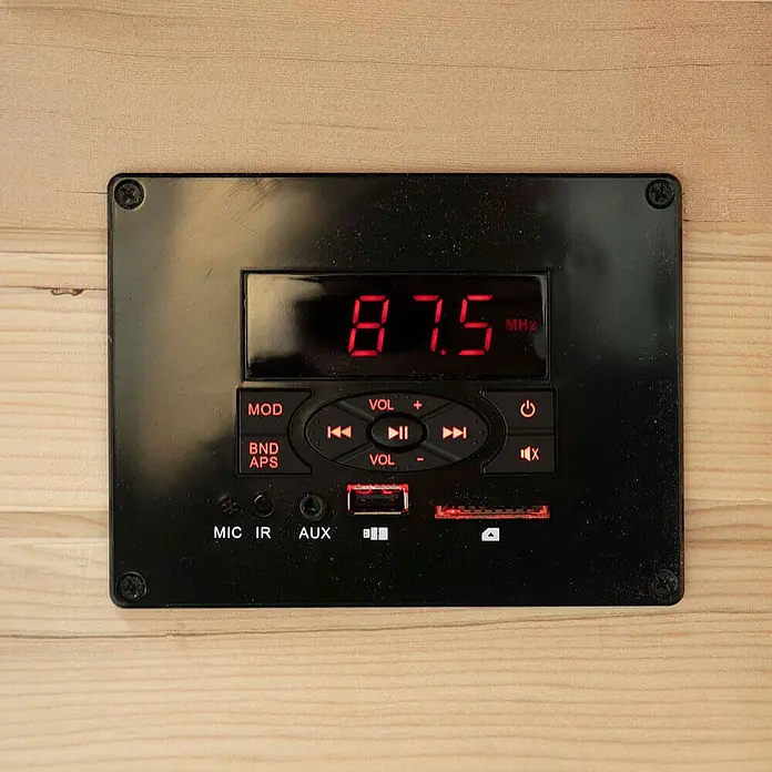 HOME DELUXE - Infrarotkabine mit Vollspektrumstrahler REDSUN M - 120 x 105 cm für 2 Personen -  - Schwarzes Audio-Bedienfeld mit rotem LED-Display (87.5 MHz), Medientasten und USB-/AUX-/SD-Anschlüssen, auf hellem Holz montiert.