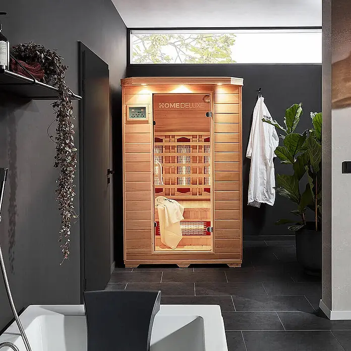 HOME DELUXE - Infrarotkabine mit Vollspektrumstrahler REDSUN M - 120 x 105 cm für 2 Personen -  - Kompakte Infrarotsauna aus hellem Holz, in einem modernen Badezimmer für persönliches Wohlbefinden.