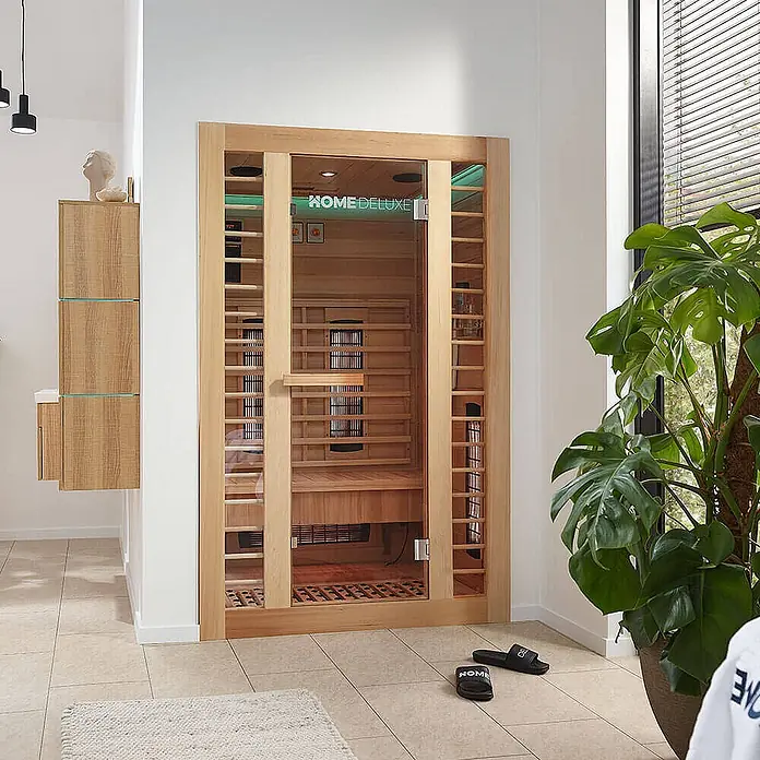 Home Deluxe Infrarotkabine REDSUM DELUXE PLUS M -  - Moderne Infrarotsauna mit hellem Holzrahmen und Glastür im Wellnessbereich.
