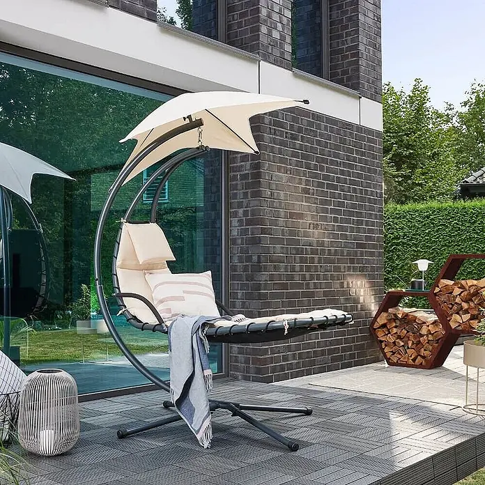 Home Deluxe Gartenliege SAN REMO - Anthrazit / Beige, Polyester - Dunkelgrauer Schaukel-Liegestuhl für den Außenbereich mit cremefarbenen Kissen, Decke und Sonnenschirm auf einer Terrasse.
