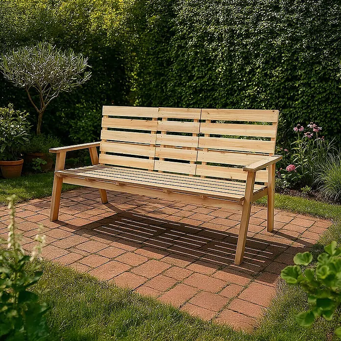 Home Deluxe Gartenbank REYA - Tannenholz, Holzfarbend, Klappbar - Helle Holzgartenbank auf einer roten Steinplatte in einem grünen Garten.