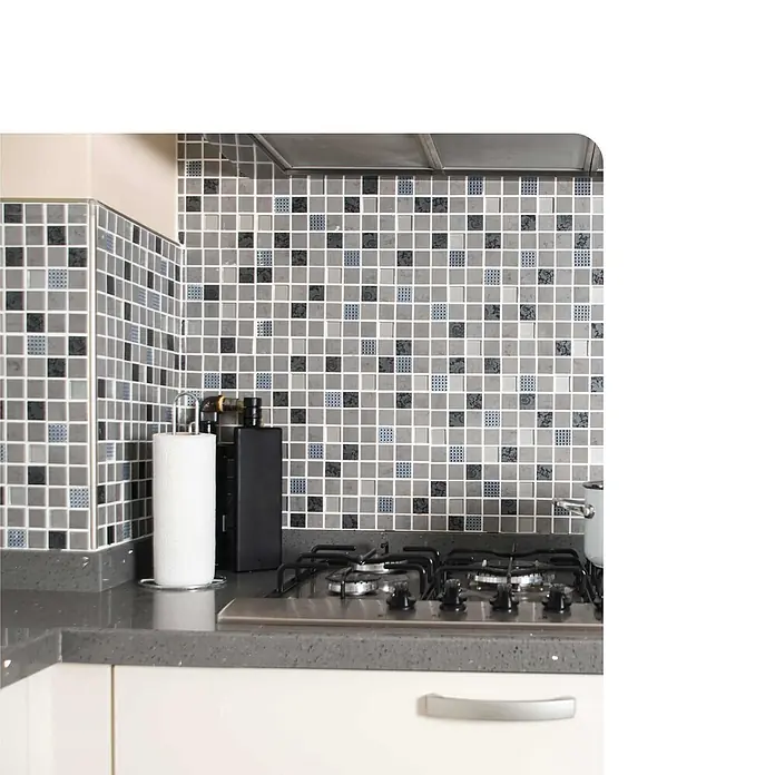 Dalsys Viertelkreis-Profil 10mm Außeneck Fliesenschiene Edelstahl Poliert - Edelstahl, Silber - Eine moderne Küche mit grauen Mosaik-Spritzschutzfliesen, einer dunkelgrauen Arbeitsplatte und einem Edelstahl-Gasherd.