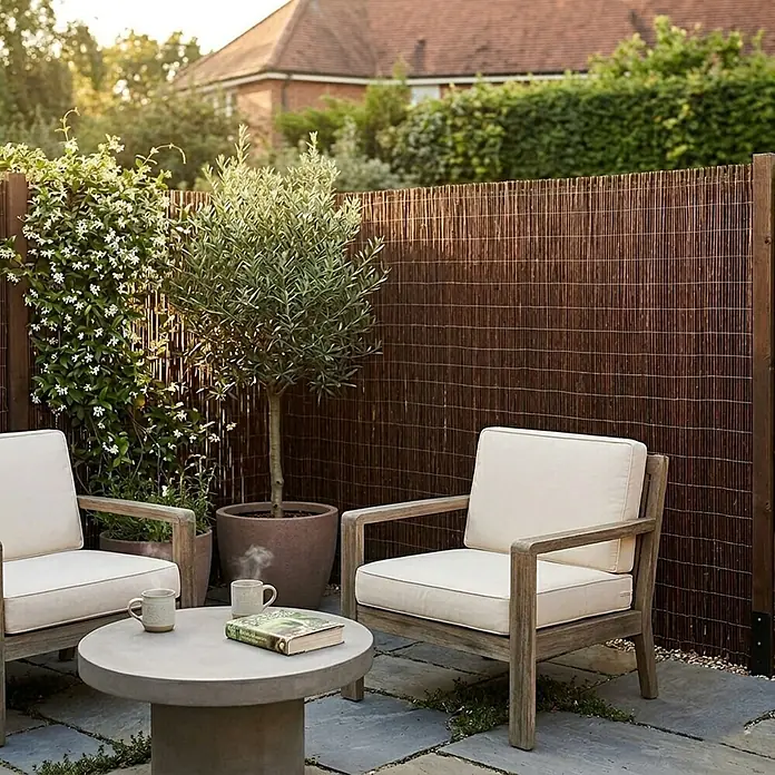 Floordirekt Sichtschutzelement Weide - B x H: 500 x 100 cm, Naturmaterialien, Braun - Dunkler Bambus-Gartensichtschutz bietet Privatsphäre auf einer Terrasse mit Gartenmöbeln.