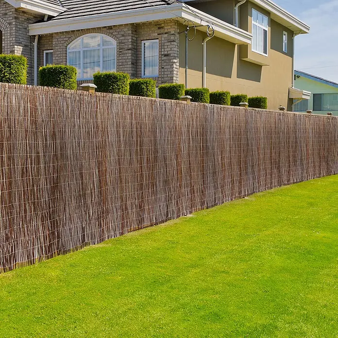 Floordirekt Sichtschutzelement Weide - B x H: 500 x 100 cm, Naturmaterialien, Braun - Brauner natürlicher Bambuszaun, der Privatsphäre in einem Garten neben einem Rasen bietet.