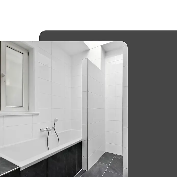 Dalsys Viertelkreis-Profil 5x Fliesenschiene 2,5m x 10mm Aluminium Schwarz - Aluminium, Schwarz - Modernes Badezimmer mit weißen Fliesenwänden, Badewanne mit dunkelgrauem Sockel und gefliester Duschabtrennung.
