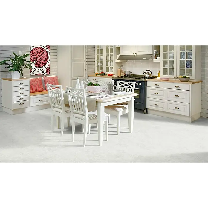 Tarkett Suelo de PVC a metros Spirit 150 - Efecto mármol, Ancho: 2 m - Un diseño de cocina que muestra una mesa de madera blanca, rodeada de sillas con cojines de rayas, con armarios blancos a juego.