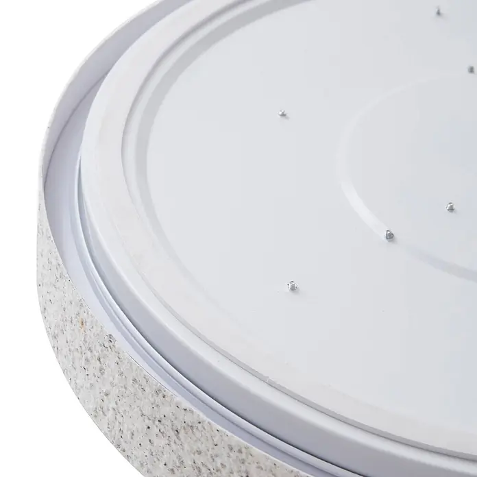Lindby Deckenleuchte Elmor - alu / grau / zink - Nahaufnahme einer runden weißen Leuchte mit gesprenkeltem Außenrand und kleinen Silberschrauben auf der Innenfläche.