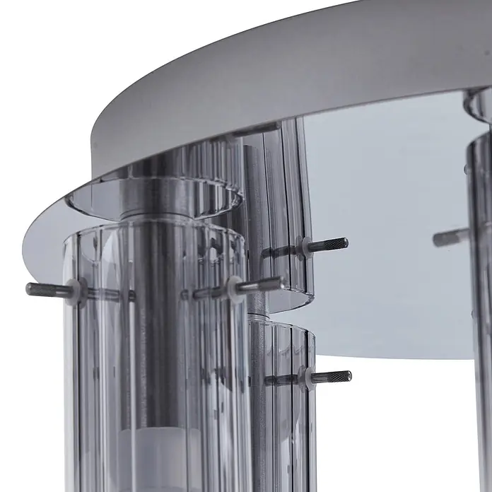 Lucande Deckenleuchte Korvitha - alu / grau / zink - Nahaufnahme einer Leuchte mit gerippten Klarglaszylindern, gehalten von silberfarbenen Metallstiften auf einer reflektierenden Basis.