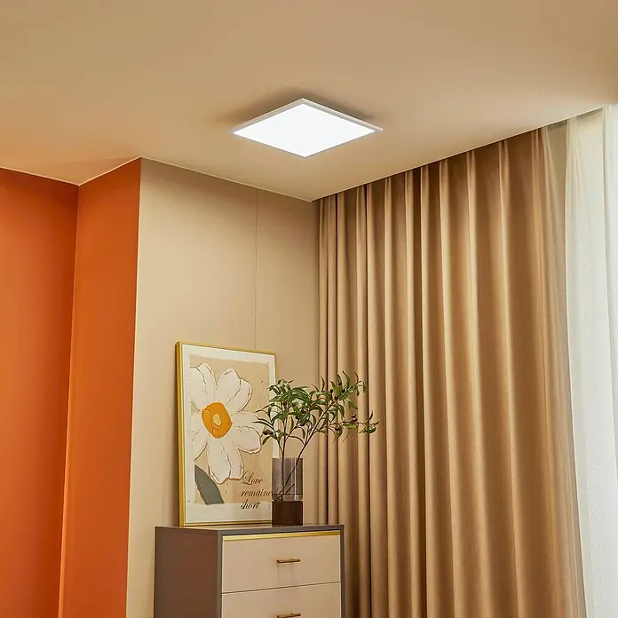Lindby LED-Panel Lamin - L x B x H: 39,5 x 39,5 x 5 cm, weiß / opal - Quadratische LED-Deckenleuchte beleuchtet einen modernen Raum mit warmen Wänden und Vorhängen.