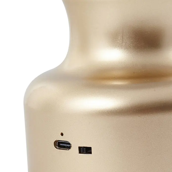 Lindby Tischleuchte Maxentius - L x B x H: 12 x 12 x 30 cm, messing / gold, alu / grau / zink - Goldfarbenes Elektronikgerät mit USB-C-Anschluss, Anzeigeleuchte und Schalter an der gewölbten Oberfläche.
