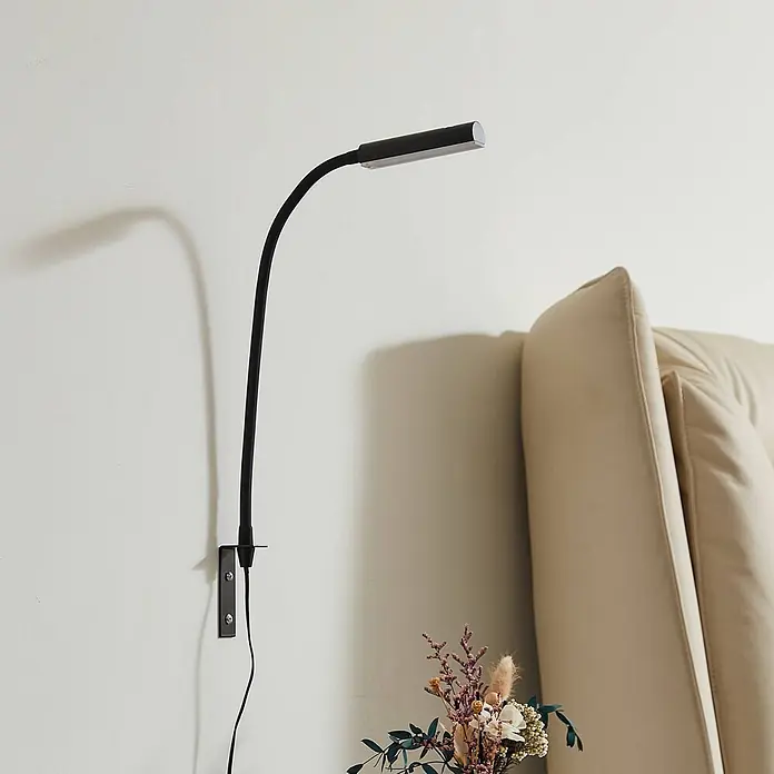 Lindby Wandleuchte Flexola - schwarz, schwarz - Schwarze wandmontierte LED-Schwanenhalslampe mit rechteckiger Lichtleiste, über einem beigen Kopfteil.
