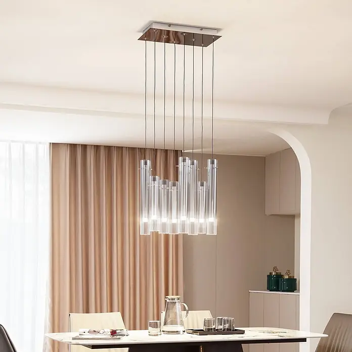 Lucande Pendelleuchte Korvitha - alu / grau / zink, rauchgrau, silber - Rechteckiger Kronleuchter mit mehreren zylindrischen Anhängern aus klarem Glas, in verschiedenen Längen über einem Esstisch in modernem Ambiente.