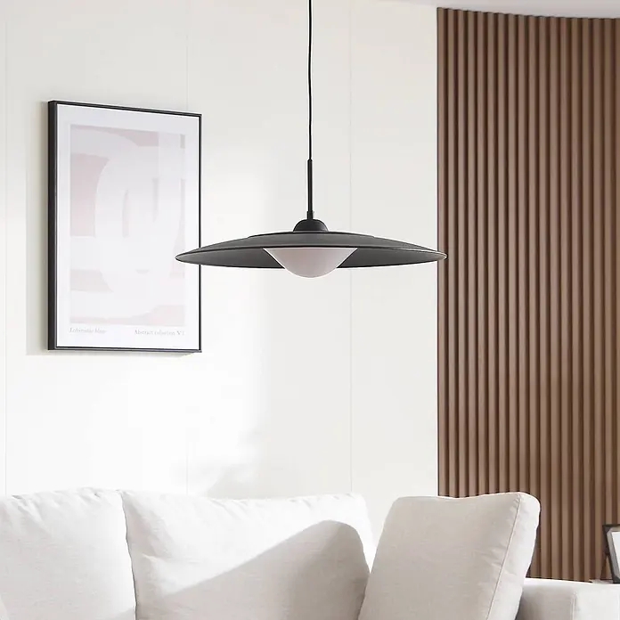 Lucande Pendelleuchte Foco - schwarz, Schwarz, weiß - Schwarze Scheiben-Pendelleuchte mit weißem Diffusor, hängt in einem modernen Wohnzimmer über einem Sofa.