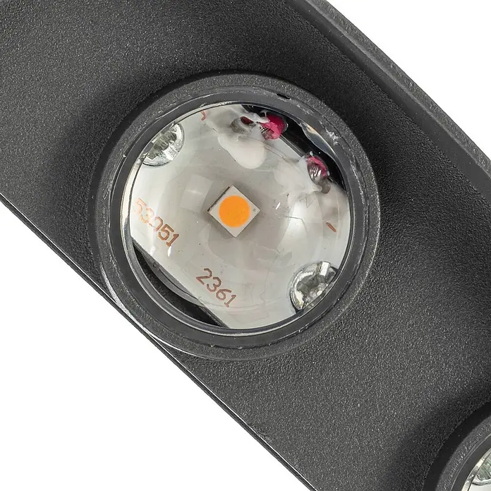 Lindby Außenwandleuchte Ithan - schwarz, IP54 - Nahaufnahme eines dunkelgrauen, strukturierten LED-Lichtmoduls mit orangefarbener LED, klarer Linse und sichtbaren Schrauben.