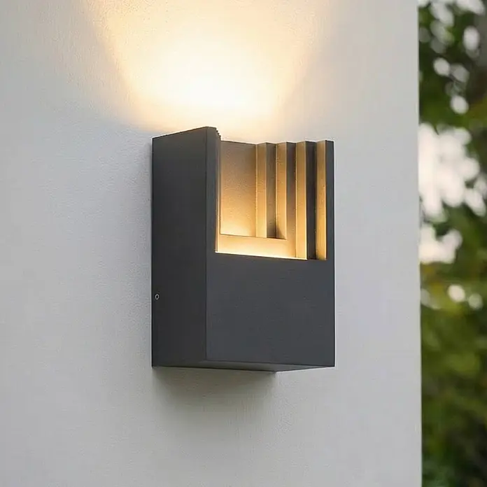 Lindby Außenwandleuchte Aurali - 6,1 x 12 x 15,7 cm, schwarz, IP65 - Anthrazitfarbene Außenwandleuchte mit geometrischem, geripptem Innendesign, die warmes Auf- und Ablicht abgibt.
