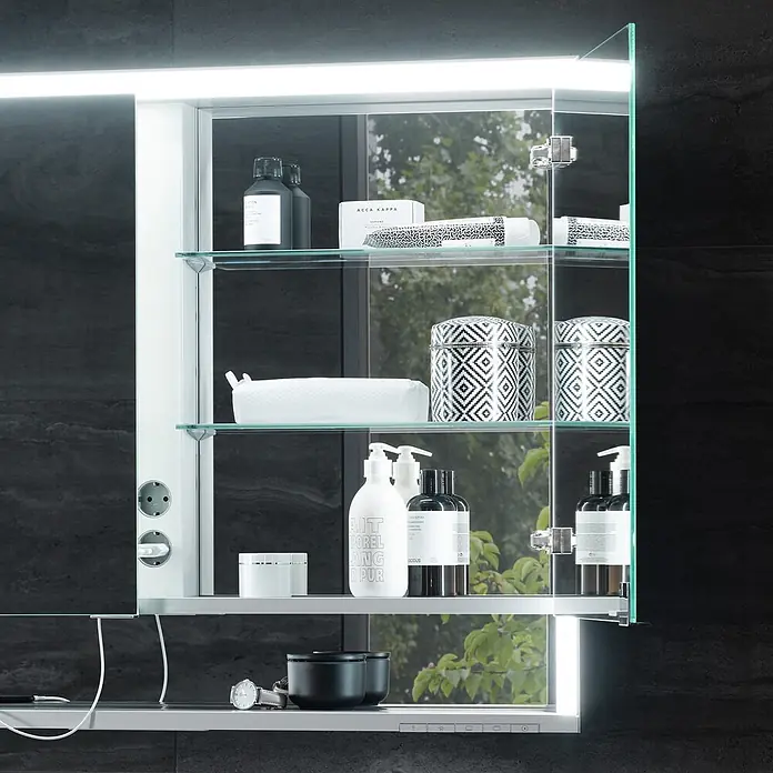 Keuco LED-Spiegelschrank Royal Lumos - B x H: 120 x 73,5 cm, Aluminium, silber-eloxiert - Ein silberner Badspiegelschrank mit integrierter Beleuchtung, Glasablagen und Steckdose, gefüllt mit Toilettenartikeln.