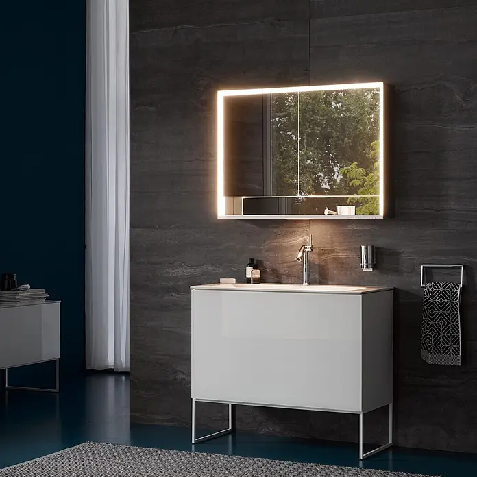 Keuco LED-Spiegelschrank Royal Lumos - B x H: 100 x 73,5 cm, Aluminium, silber-eloxiert - Moderner, hochglänzender weißer Badunterschrank mit integriertem Waschbecken und beleuchtetem Spiegelschrank in einem eleganten Badezimmer.