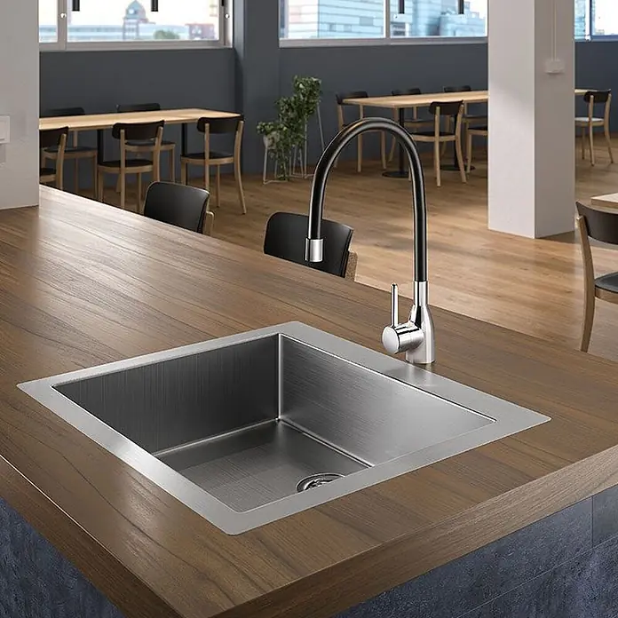 Delabie Spültischarmatur Delabie -  - Edelstahlspüle mit schwarzem und verchromtem Schwanenhalsarmatur, in eine Holztheke in einem modernen Café eingebaut.