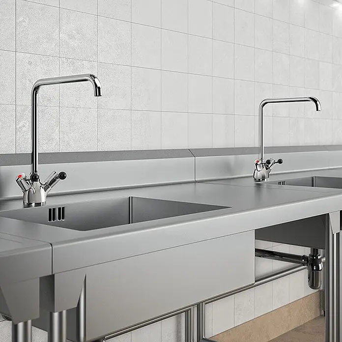 Delabie Spültischarmatur Delabie -  - Edelstahl-Arbeitsplatte mit zwei Spülbecken und hohen Chrom-Armaturen, für gewerbliche Küchen.