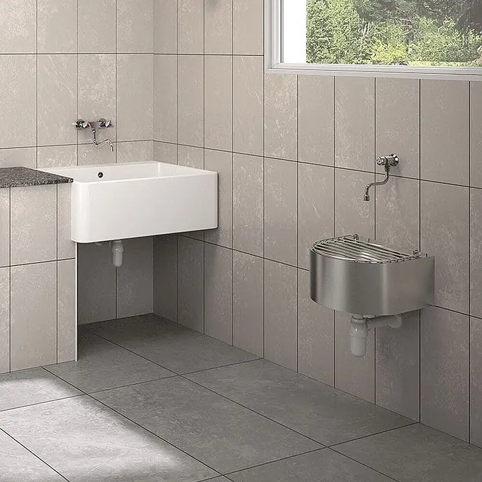 Delabie Spültischarmatur Delabie -  - Zwei Wandwaschbecken: ein rechteckiges weißes Keramikbecken mit Ablage und ein gebogenes Edelstahl-Fußwaschbecken.
