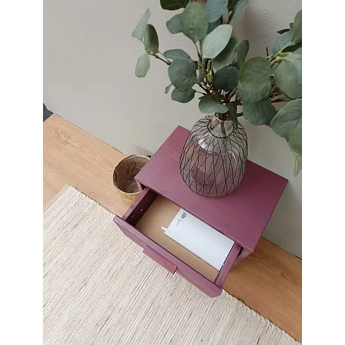 Astigarraga Vita Mesita de noche - L x An x Al: 25 x 40 x 50 cm, Natural, Número de cajones: 1 ud. - Pequeño mueble de madera magenta con un cajón abierto. Encima, un jarrón con ramas de eucalipto.