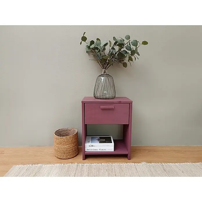 Astigarraga Vita Mesita de noche - L x An x Al: 25 x 40 x 50 cm, Natural, Número de cajones: 1 ud. - Mesita de noche rojizo-morada con cajón y estante abierto, con jarrón con follaje y libros, junto a una cesta.