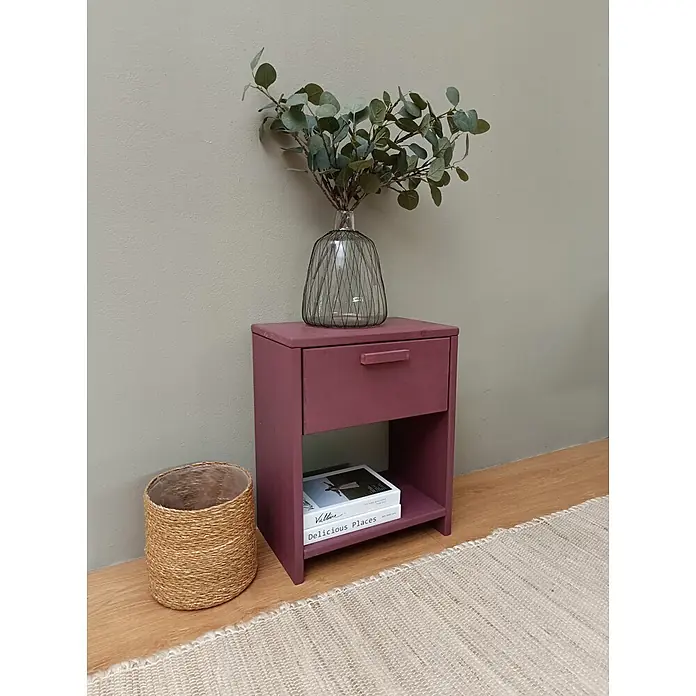 Astigarraga Vita Mesita de noche - L x An x Al: 25 x 40 x 50 cm, Natural, Número de cajones: 1 ud. - Mesita de noche de madera rosa oscuro con cajón y estante abierto, decorada con un jarrón y libros, junto a una cesta y una alfombra.