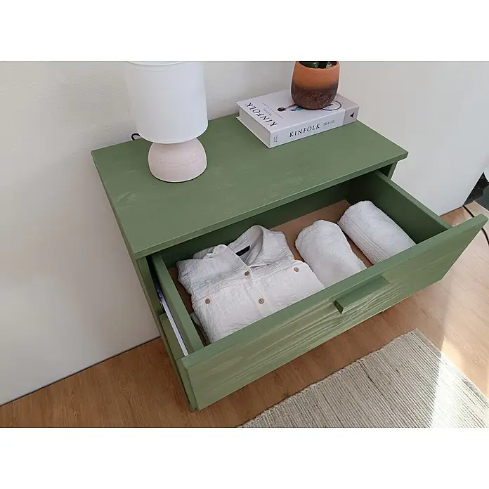 Astigarraga Vita Cómoda - L x An x Al: 36 x 65 x 96 cm, Natural, Número de cajones: 4 ud. - Cajón de madera verde con cajón abierto conteniendo camisa blanca y toallas. Lámpara, libro y planta encima.