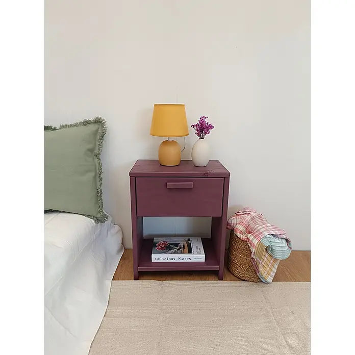 Astigarraga Vita Mesita de noche - L x An x Al: 25 x 40 x 50 cm, Natural, Número de cajones: 1 ud. - Mesita de noche de madera morada con cajón y estante abierto, junto a una cama.