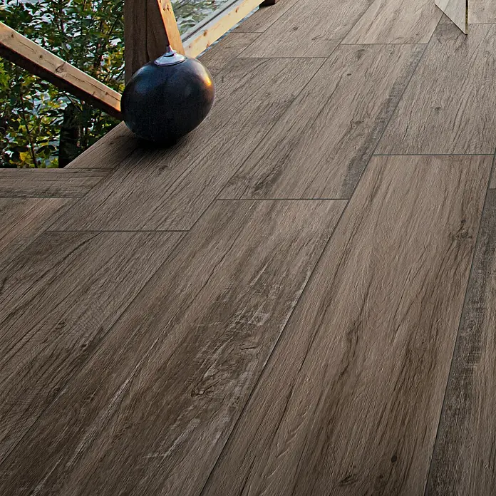 Terrassenfliese Essenze 2.0 - 40 x 120 x 2 cm, Musk, Matt - Bräunlich-graue Fliesen in Holzoptik, die eine natürliche Holzterrasse nachahmen und eine authentische Maserung aufweisen.