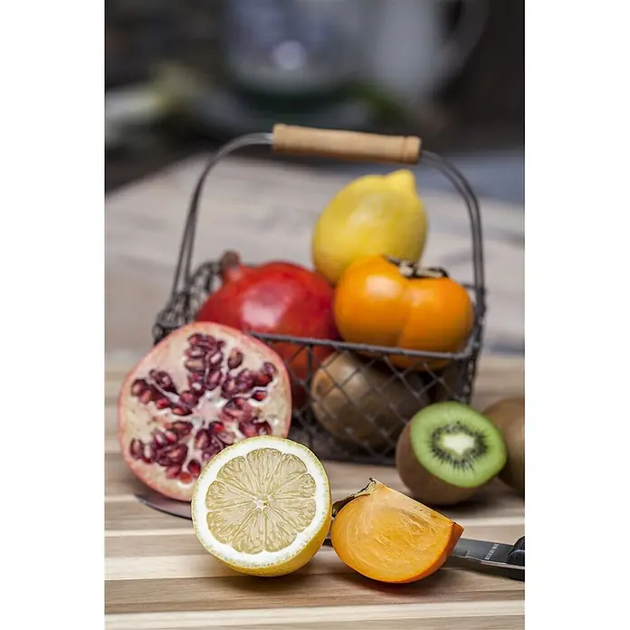 Pflanzen für dich Obstbaum 125-150 cm - Diospyros kaki 'Ernesto' - Verschiedene frische Früchte, teils ganz, teils geschnitten, darunter Granatapfel, Zitrone, Kaki und Kiwi, auf einem Holzbrett.