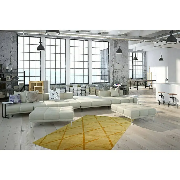 Kayoom Kurzflorteppich Luxury 210 - Gelb, 290 x 200 cm, 100 % Viskose - Ein modernes Wohnzimmer mit einem beigen Ecksofa, Hockern und einem auffälligen gelben Teppich mit geometrischen Mustern.