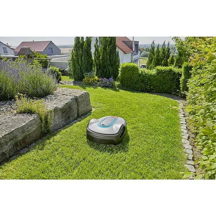 Gardena Ersatzmesser - Gardena Mähroboter - Ein Gardena Mähroboter auf einem grünen Rasen in einem gepflegten Garten. Der Rasenmäher ist grau und schwarz.