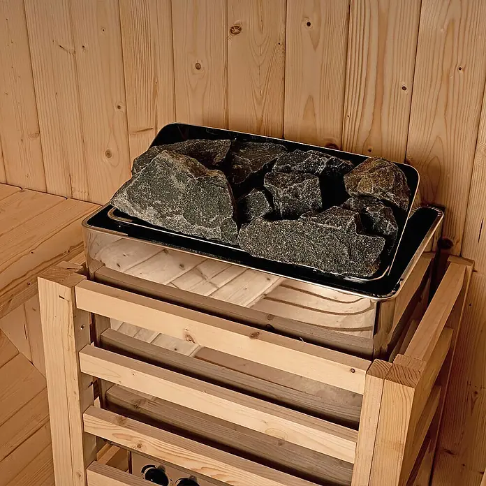 Home Deluxe Fasssauna LAHTI XL - Elektroofen, Holz, L x B x H: 220 x 189 x 191,5 cm - Saunaofen mit dunkelgrauen Steinen in einer Holzsauna. Der Metallofen ist teilweise von einem Holzlattenrost umgeben.