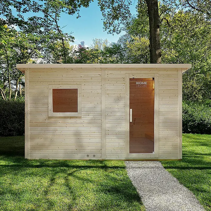 Home Deluxe Fasssauna TALO XL - Elektroofen, Holz - Helle Holz-Außensauna mit Glastür und Fenster, auf einem Kiesweg in einem sonnigen Garten.