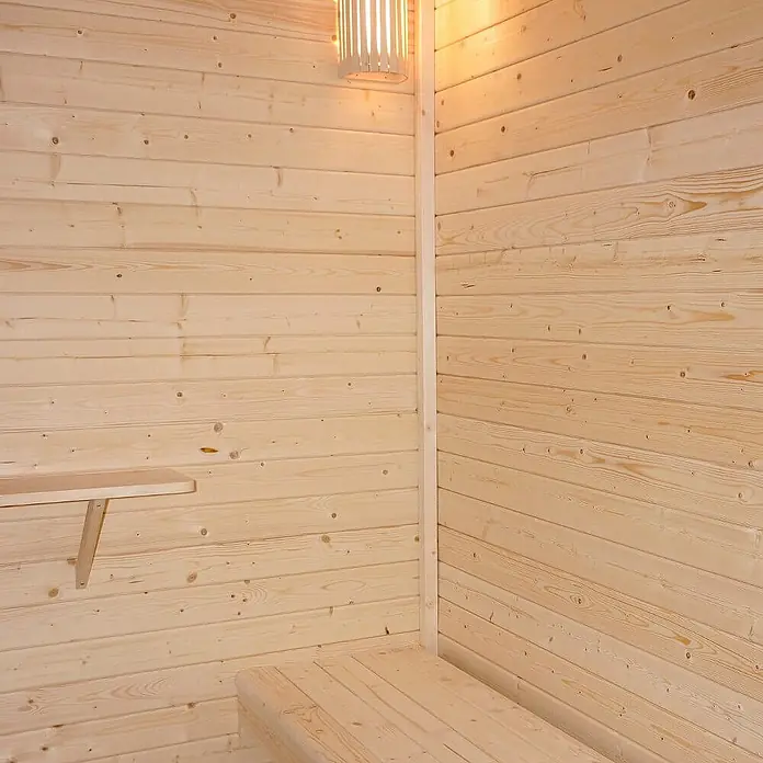 Home Deluxe Fasssauna TALO XL - Elektroofen, Holz - Helle Holzsauna-Einrichtung mit Paneelwänden, einer Bank, einem Regal und einer Lamellenleuchte.